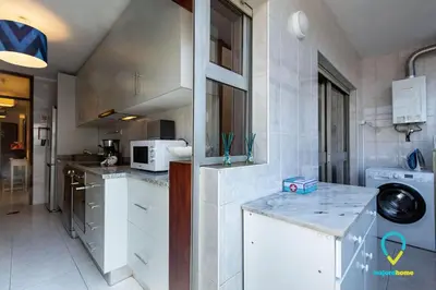 a kitchen with white cabinets and a counter top at Camilo Apartment in Porto