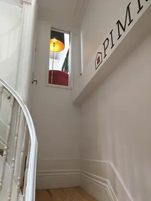 a white staircase with a red chair in the window at Pimms Home Ribeira in Porto