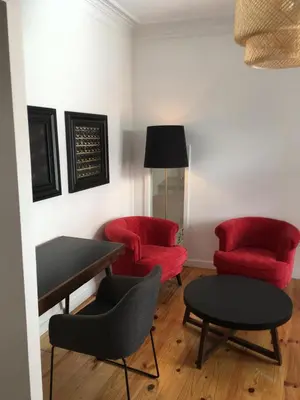 a living room with two red chairs and a table at Pimms Home Ribeira in Porto