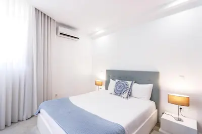 a bedroom with a large white bed with two lamps at HM - Nearby Bolhão Studio in Porto