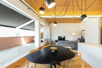 a dining room and living room with a table and chairs at Mouzinho Village River in Porto