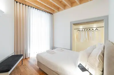 a bedroom with a large white bed and a window at Mouzinho Village River in Porto