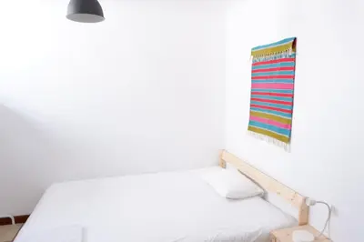 a white room with a bed and a flag on the wall at Kame House in Vila Nova de Gaia