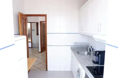 a kitchen with white tile walls and a sink at Kame House in Vila Nova de Gaia