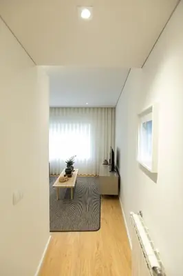 a living room with white walls and a table at Ninon- Premium Trindade by Porto City Hosts in Porto