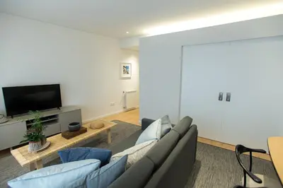 a living room with a couch and a tv at Ninon- Premium Trindade by Porto City Hosts in Porto