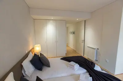 a bedroom with a white bed with a lamp at Ninon- Premium Trindade by Porto City Hosts in Porto