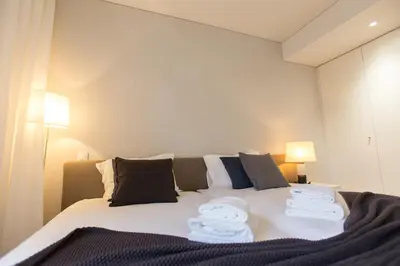 a bedroom with a bed with towels on it at Ninon- Premium Trindade by Porto City Hosts in Porto