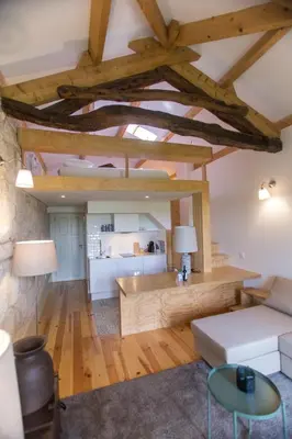 a living room with wooden floors and a ceiling with beams at Picasso Suites Porto by PCH in Porto