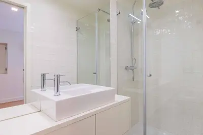 a white bathroom with a sink and a shower at Lemago Porto Apartments - Sé in Porto