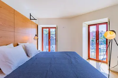 a bedroom with a blue bed with white pillows at Lemago Porto Apartments - Sé in Porto