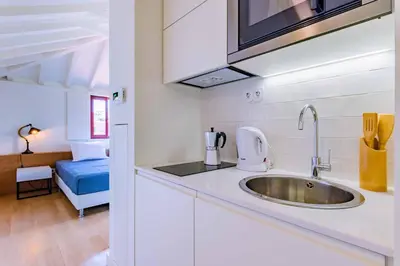 a kitchen with a sink and a room with a bed at Lemago Porto Apartments - Sé in Porto