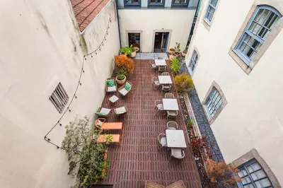a patio with tables and chairs on a wooden deck at Casa dos Lóios by Shiadu in Porto