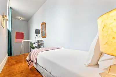 a white bedroom with a bed and a chair at Casa dos Lóios by Shiadu in Porto