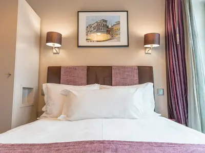 a bedroom with a white bed with two lights on the wall at Guest House Douro in Porto