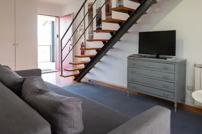 a living room with a couch and a tv on a dresser at Casas do Teatro in Porto