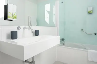 a white bathroom with a sink and a tub at Casas do Teatro in Porto