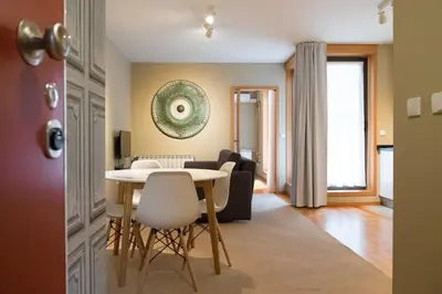 a dining room and living room with a table and chairs at Casas do Teatro in Porto