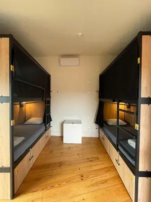 two bunk beds in a room with wooden floors at Onefam Ribeira in Porto