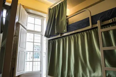 a bedroom with a green curtain and a window at Onefam Ribeira in Porto