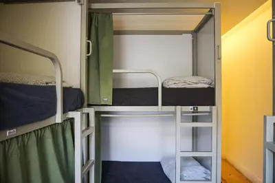 two bunk beds in a room with a ladder at Onefam Ribeira in Porto