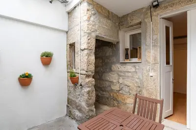 a wooden bench sitting next to a wall with plants at ZD Moreira Flats A By PortoProperties4You in Porto