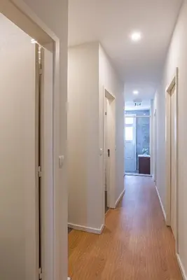 an empty hallway with white walls and wood floors at ZD Moreira Flats A By PortoProperties4You in Porto