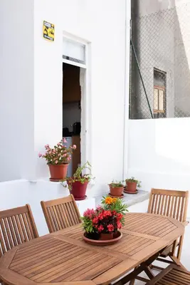 a wooden table with chairs and flowers on a patio at ZD Moreira Flats C By PortoProperties4You in Porto