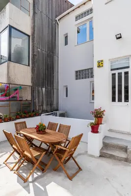 a patio with a wooden table and chairs at ZD Moreira Flats C By PortoProperties4You in Porto