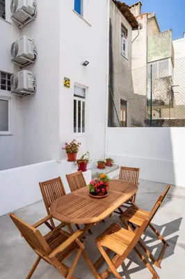 a wooden table and chairs on a patio at ZD Moreira Flats C By PortoProperties4You in Porto
