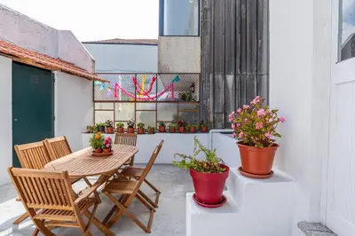a patio with a table and chairs and potted plants at ZD Moreira Flats C By PortoProperties4You in Porto