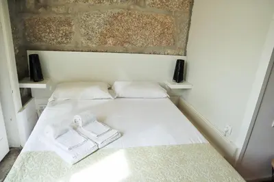 a small white bed with two towels on it at ZD Moreira Flats E By PortoProperties4You in Porto