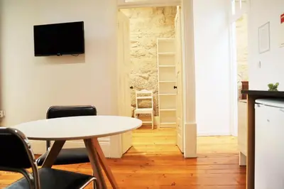 a living room with a table and chairs and a tv at ZD Moreira Flats E By PortoProperties4You in Porto