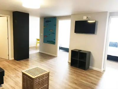 a living room with a flat screen tv and fish on the wall at Camões Lookout in Porto
