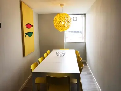 a dining room with a white table and yellow chairs at Camões Lookout in Porto