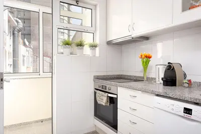 a kitchen with white cabinets and a black oven at Big Families & Groups Bonjardim views 5 bedrooms 3 bathrooms in Porto