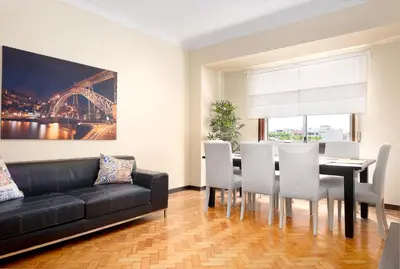 a living room with a black couch and a table and chairs at Big Families & Groups Bonjardim views 5 bedrooms 3 bathrooms in Porto