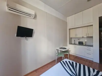 a white room with a table and a tv on the wall at Loulé Estúdios in Porto