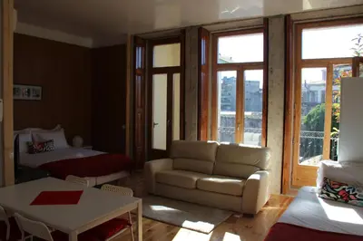a living room with a couch and a bed at Loulé Estúdios in Porto
