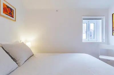 a white bedroom with a bed and a window at Design Boavista Music Home in Porto