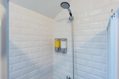 a shower in a bathroom with white tiled walls at Design Boavista Music Home in Porto