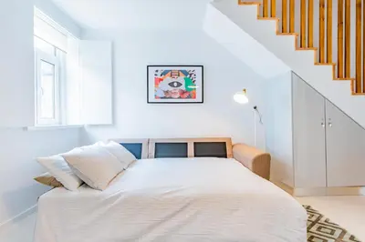 a white bedroom with a bed and a staircase at Design Boavista Music Home in Porto