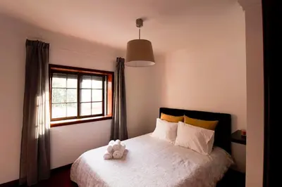 a bedroom with a bed with a teddy bear on it at A Ilha do Lindo Vale in Porto