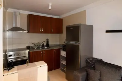 a kitchen with a stainless steel refrigerator and wooden cabinets at A Ilha do Lindo Vale in Porto