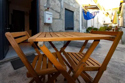 a wooden picnic table and two chairs on a patio at A Ilha do Lindo Vale in Porto
