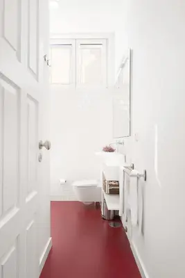 a bathroom with a white sink and a red floor at Host Wise - Oporto Classic Apartment in Porto