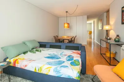 a bedroom with a bed and a living room at Porto Insight Cedofeita- Parking, Balconies & AC in Porto