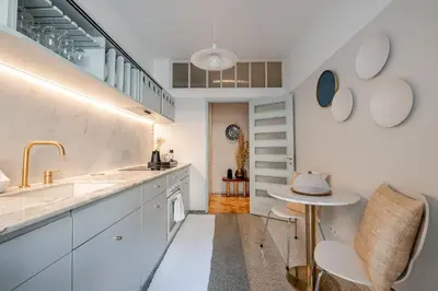 a kitchen with white cabinets and a sink at UNIQUE Modernist Duplex apartment & PARKING in Porto