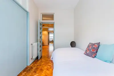 a bedroom with a white bed and a hallway at UNIQUE Modernist Duplex apartment & PARKING in Porto