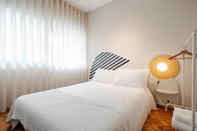 a bedroom with a white bed and a lamp at UNIQUE Modernist Duplex apartment & PARKING in Porto